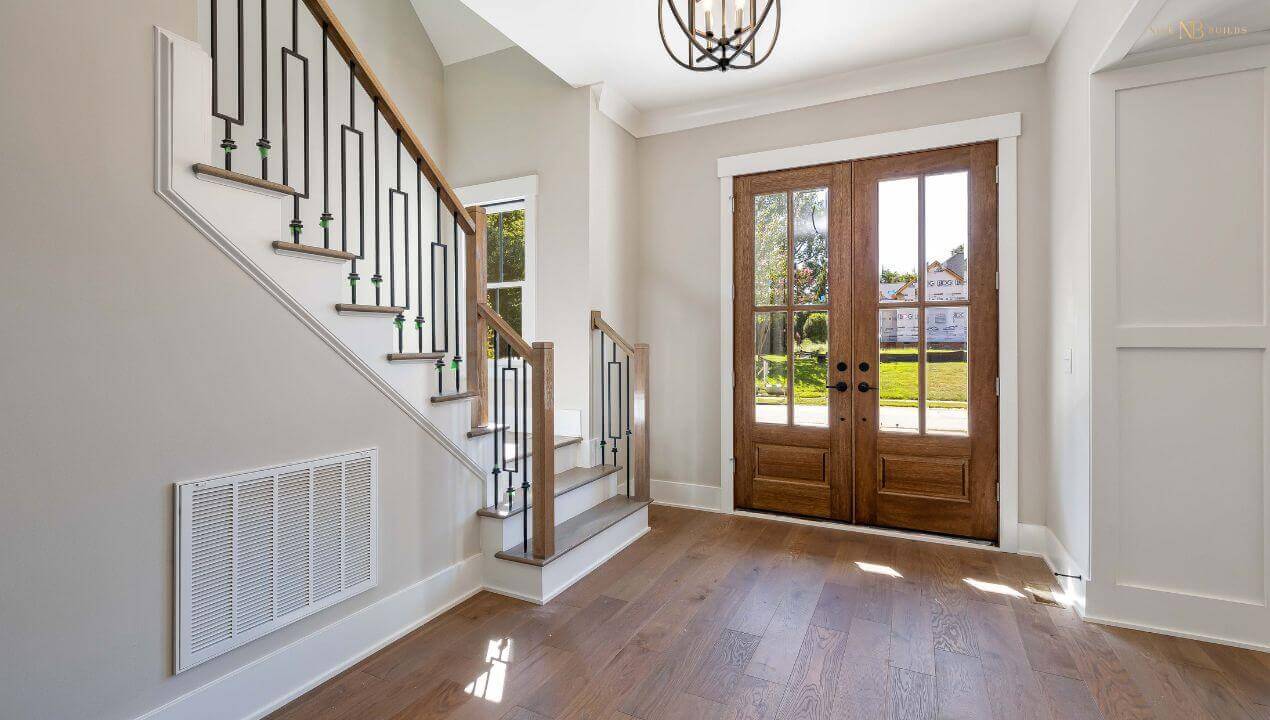 The entrance of a well-lit home leading to a staircase depicting what a good house orientation can do.