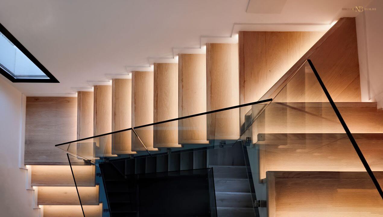 Modern wooden staircase with glass balustrades and integrated under-step lighting