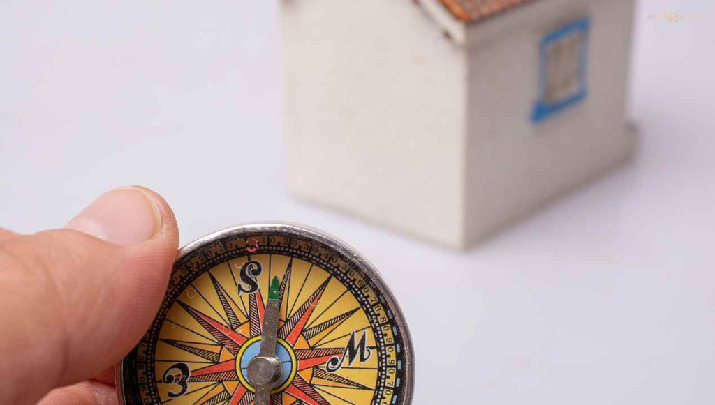 a compass tool before a tiny model house