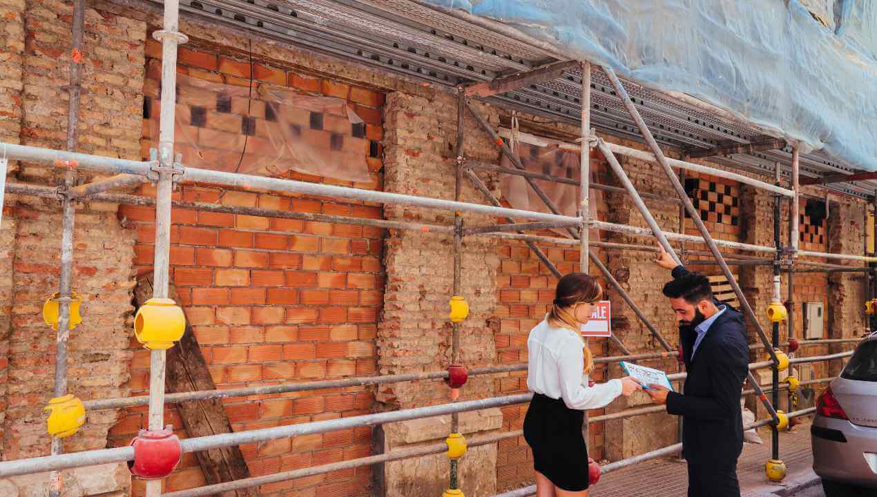 builders discussing a knockdown rebuild beside a fenced home